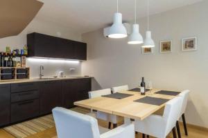 a kitchen with a wooden table and white chairs at Sea view House Fontera in Rovinj