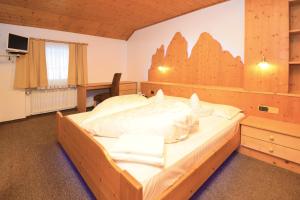 una camera da letto con un letto grande in una stanza di Hotel Chalet Olympia a Monguelfo Altre 37 foto