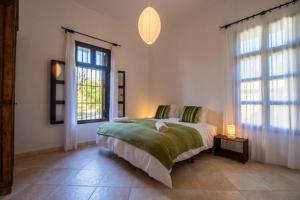 1 dormitorio con 1 cama y 2 ventanas en Floating House Tarifa, en Tarifa