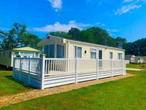 Casa móvil con valla blanca en Forest Haven, en Sway