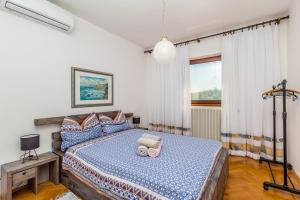 1 dormitorio con 1 cama con edredón azul en Apartments Balić - Pinezići, Krk, en Pinezici
