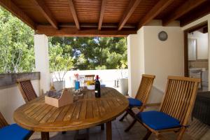 a wooden table with chairs and a bottle of wine at Gran Apartamento en Puerto in Port de Pollensa