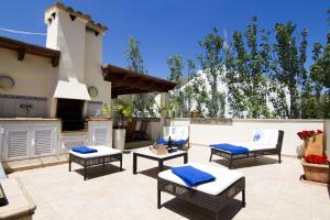 a patio with four chairs and a grill and a kitchen at Gran Apartamento en Puerto in Port de Pollensa