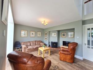a living room with leather furniture and a fireplace at 68 Clifden Glen in Clifden