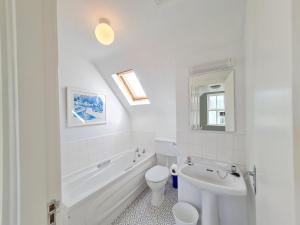 a white bathroom with a tub and a toilet and a sink at 68 Clifden Glen in Clifden +52 photos