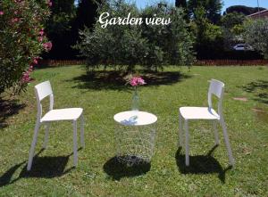 two chairs and a table with a vase of flowers at Florence Chic, garden and parking in Florence