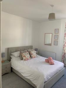 a bedroom with a white bed with pillows and a mirror at Hideaway House in Bridlington