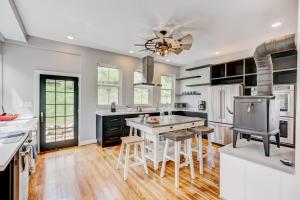 a kitchen with white counters and a kitchen island with stools at Josephine Cottage in Hot Springs