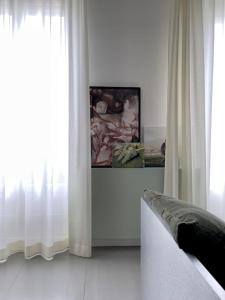 パリにあるBright & Modern Studio With Great Sun Exposureのリビングルーム(白いカーテン、ソファ付)
