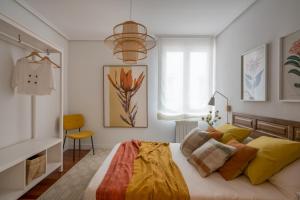 um quarto com uma cama grande e almofadas amarelas em New Zubizuri by Staynnapartments em Bilbao