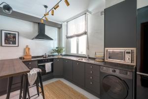 uma cozinha com um lavatório e um micro-ondas em New Zubizuri by Staynnapartments em Bilbao
