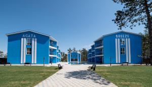 due edifici blu con panchine in un parco di Agata Breeze a Kobleve