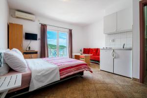 a bedroom with a large bed and a kitchen at Apartments Njavro Neum in Neum