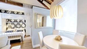 - une salle à manger avec une table blanche et un lit bébé dans l'établissement La Casa nel Castello, à Ostie