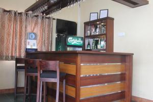 a bar with two chairs and a television at Grand 7 Hotel Thalawathugoda in Talawatugoda