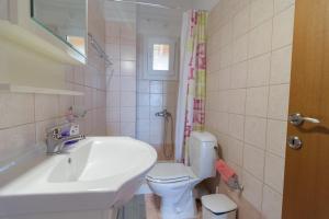 a bathroom with a sink and a toilet at Kostas & Eleni Apartments in Sotirítsa +25 photos