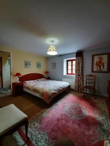 ein Schlafzimmer mit einem großen Bett und einem roten Teppich in der Unterkunft TY KOANT in Daoulas
