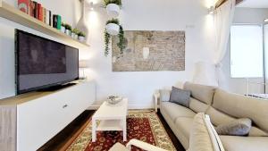 a living room with a couch and a flat screen tv at La Casa nel Castello in Ostia Antica