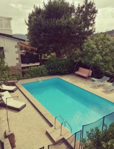 a swimming pool in a yard with chairs and a house at Piedra Libre Apartamentos in Manzanares el Real