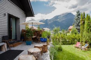 a patio with a table and chairs and an umbrella at Zugspitzloft in Ehrwald