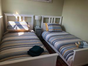 two beds sitting next to each other in a bedroom at Cox`s Pond View in Harwich