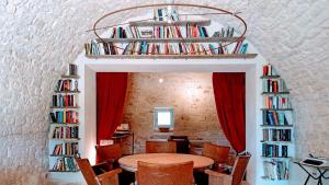 a dining room with a table and bookshelves at Masseria LoJazzo in Ceglie Messapica