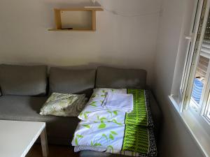 un sofá con 2 almohadas junto a una ventana en Apartamenty przy plaży Graniczna 4, en Pobierowo