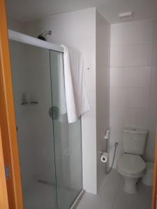 a bathroom with a toilet and a glass shower stall at Acomodação Tranquila (Centro de Campos) in Campos dos Goytacazes