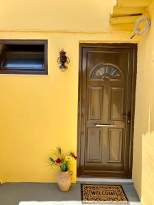 a door to a yellow building with a plant next to it at Mama'sEvdokia Apartment in Rhodes Town