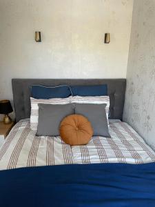 a bed with blue and white pillows and a brown bowl on it at Apartament Marble Wave Rowy in Rowy