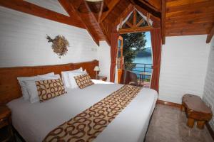 a bedroom with a large bed in a room with a window at Costa Brava Apart Hotel & Suites in San Carlos de Bariloche