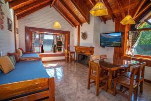 a living room with a table and a dining room at Costa Brava Apart Hotel & Suites in San Carlos de Bariloche