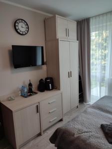 a bedroom with a large white cabinet and a clock at Apartament Dominikana in Sianozety
