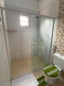 ein Badezimmer mit Glasdusche und Toilette in der Unterkunft Rancho Lisboa Cocal in Queimada