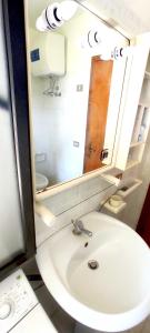 a bathroom with a white sink and a mirror at La Dolce Vista in Magomadas +20 photos