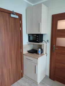 a small kitchen with a microwave and a door at Apartament Dominikana in Sianozety