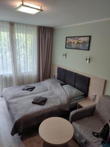 a bedroom with a bed and a couch and a table at Apartament Dominikana in Sianozety