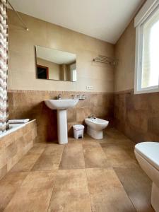 a bathroom with a sink and a toilet and a mirror at Hostal Eden in Sanxenxo