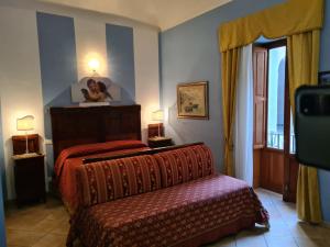 1 dormitorio con 1 cama, 2 lámparas y ventana en Artemide, en Siracusa
