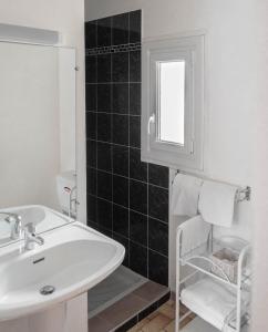 La salle de bains est pourvue d'un lavabo blanc et d'un miroir. dans l'établissement Ferme Auberge Ibarnia, à Lecumberry