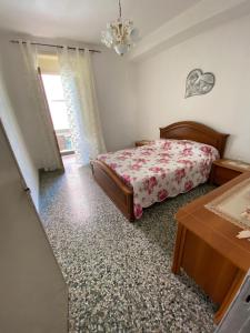1 dormitorio con 1 cama y 1 mesa en Casa Vacanza Santa Teresa di Riva, en Santa Teresa di Riva