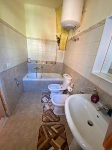 y baño con 2 aseos, lavamanos y bañera. en Casa Vacanza Santa Teresa di Riva, en Santa Teresa di Riva