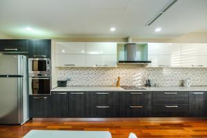 a kitchen with black cabinets and a stainless steel refrigerator at Megafun Residance B1 in Baku