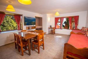 uma sala de estar com uma mesa e cadeiras e um sofá em Costa Brava Apart Hotel & Suites em San Carlos de Bariloche