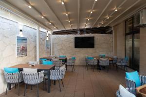 a restaurant with tables and chairs and a flat screen tv at Vila Gama in Lozenets