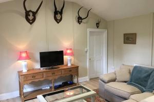 sala de estar con sofá y mesa con TV. en Private Annex near Melton Mowbray, en Melton Mowbray