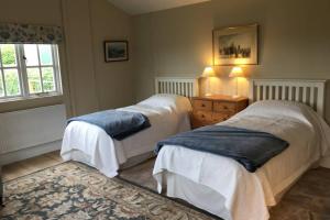 a bedroom with two beds and a dresser and a window at Private Annex near Melton Mowbray in Melton Mowbray