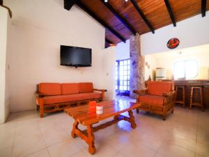 a living room with a couch and a table and a tv at Casa de las Cruces Taxco in Taxco de Alarcón