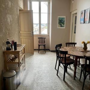a dining room with a table and chairs and a window at Café Vélo Nevers in Nevers +4 photos