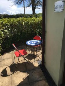 una mesa y dos sillas sentadas en un patio en Taliesin at The Poplars, Nr Saundersfoot en Pembrokeshire